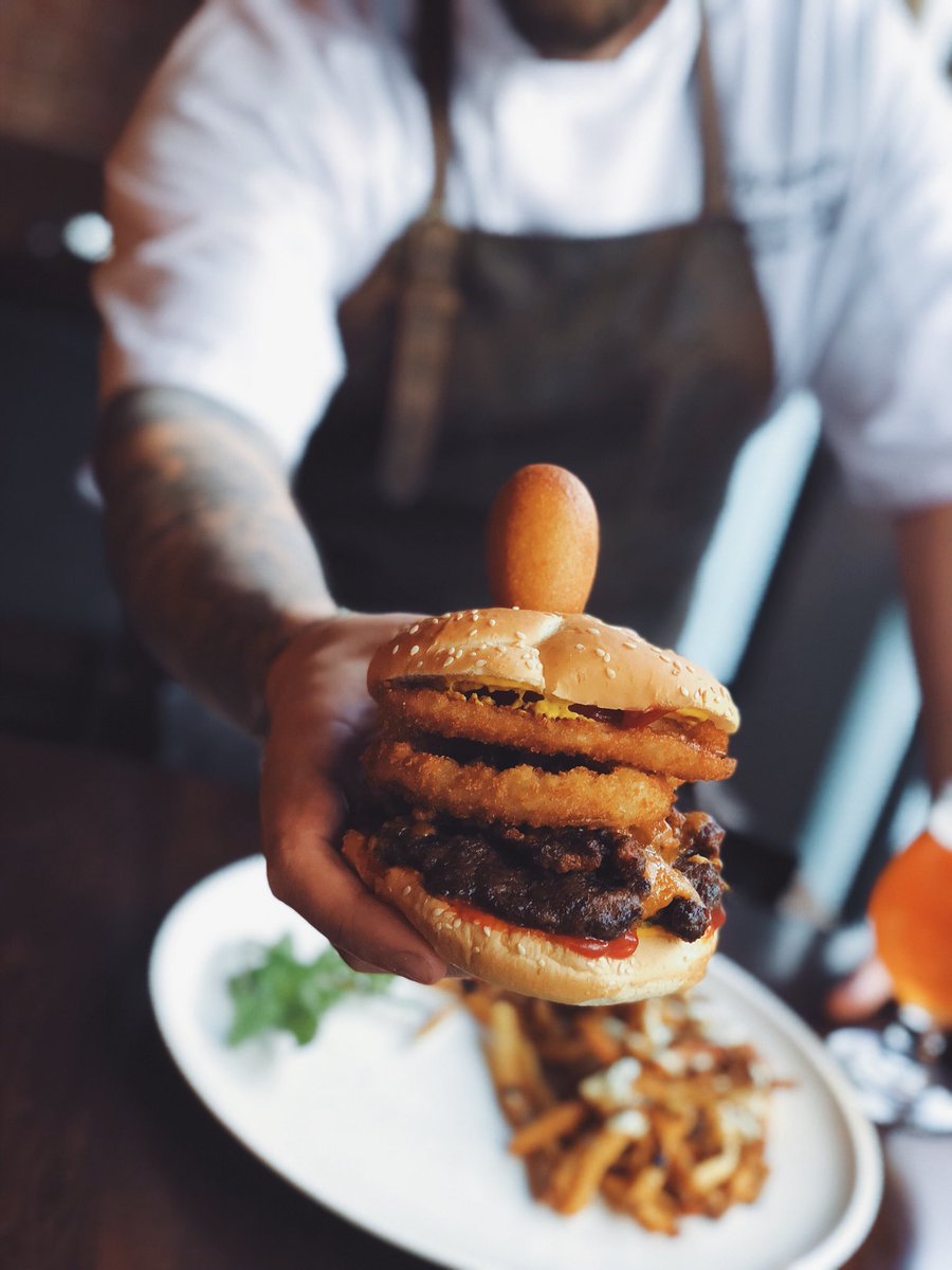 The Carnival Burger: Atlantic beef patty topped with ketchup, mustard, cheese, onion rings, chili, and a pogo - just like you got at the carnival. Served on a sesame bun. #hfxburgerweek