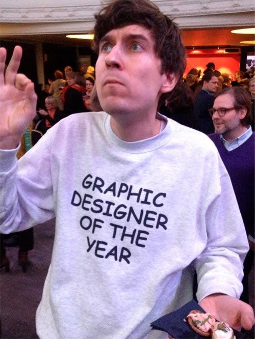 Delahuntagram's tweet image. This guy won graphic designer of the year. He responded by making himself a t-shirt. Using Comic-sans font. Brilliant.