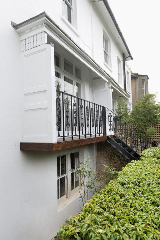 An existing external metal fire escape stair was removed from the back of the building which contains a number of flats. A new traditionally detailed balcony, canopy and steps down to the rear garden were designed and constructed to the raised ground floor flat.