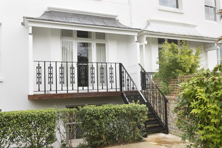 An ugly fire escape transformed by designing and changing it to a traditional balcony, canopy and stairs.