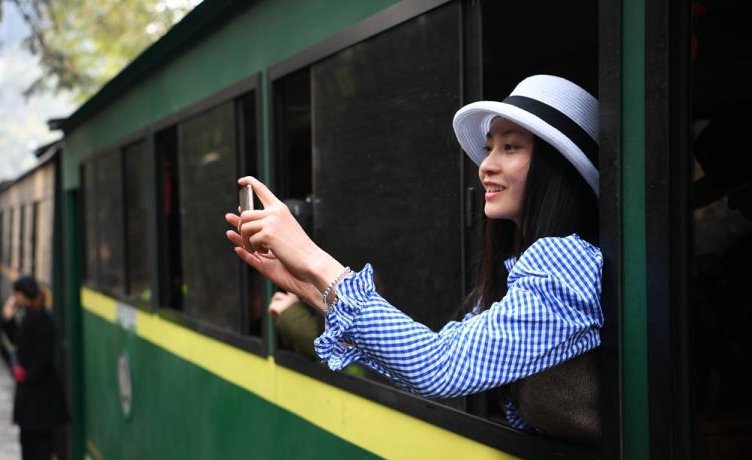 CCTV's tweet image. A Jiayang steam train runs along fields with blooming rapeseed and peach flowers in Qianwei County, southwest China's Sichuan Province.