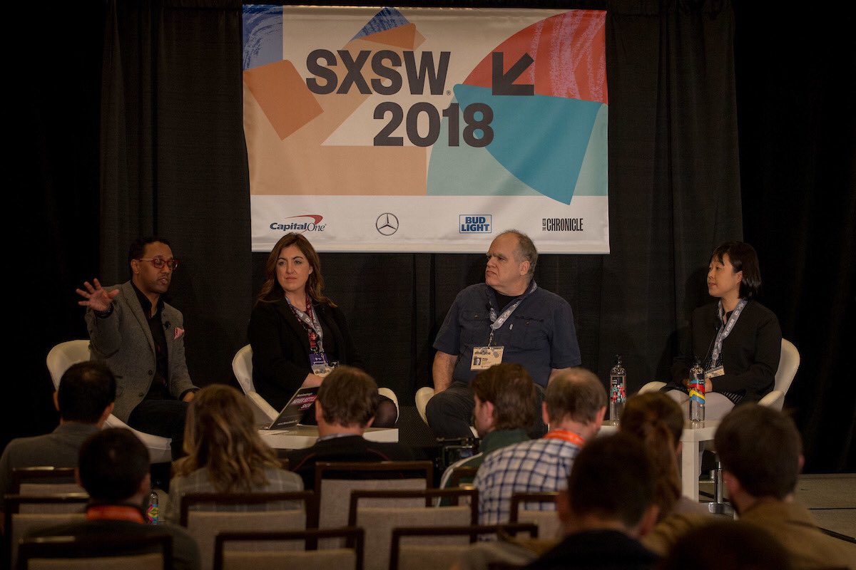 All four presenters seated on stage in front of SXSW banner