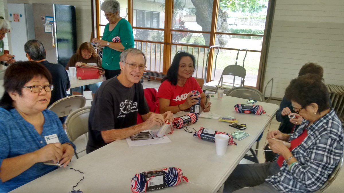 pnish75's tweet photo. 2nd annual Leis of Aloha project. Making yarn leis for the Girl Scouts to place on veterans graves at the Kaneohe Veterans  Cemetery on Memorial day   AARP volunteers showing their craftier side. @AARPHawaii #AARPHIserv https://t.co/s5jTrHaVsz