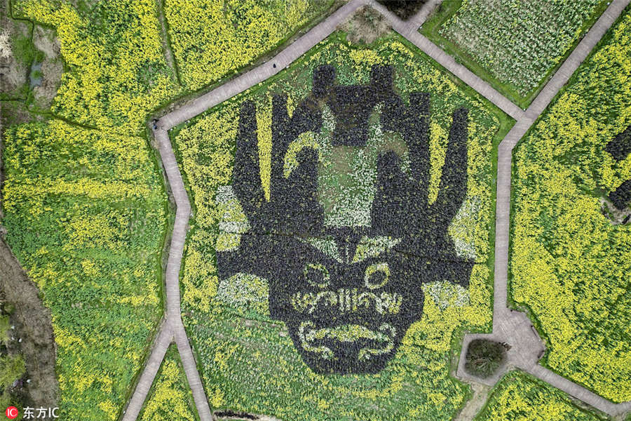 ChinaDaily's tweet photo. The landscape, 40 meters high and 40 meters wide, was planted with three kinds of #canola flowers colored yellow, white and purple. The #NuoOpera mask is a major prop of the national intangible cultural heritage Nuo Opera. https://t.co/mCLOks7wbZ