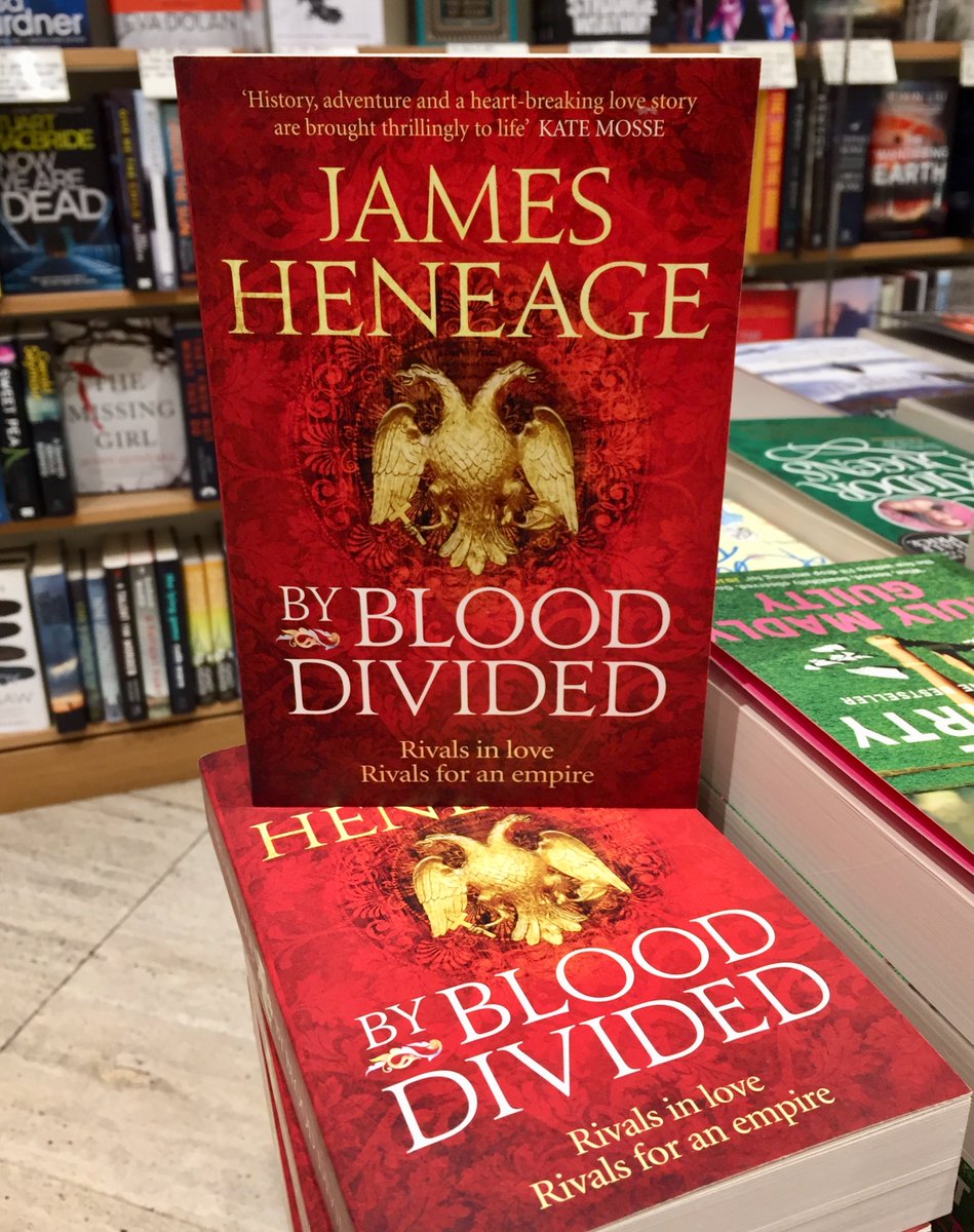Shroni's tweet photo. Absolutely thrilling seeing a book I worked on out in the wild. @jamesheneage's By Blood Divided was so good I ended up taking a holiday to Madeira. Now I'm working on his next one and the Peloponnese is calling... https://t.co/p0u2T5JkAI