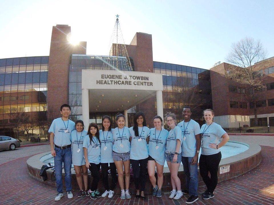 ten aggies standing outside of the Eugene J Towbin Healthcare Center on a sunny day