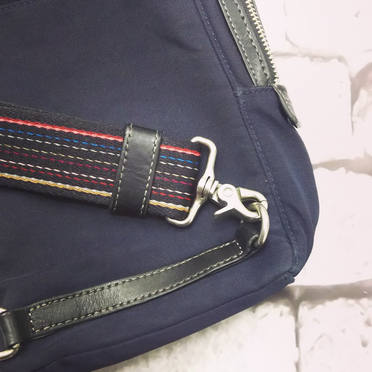 thread_needlejp's tweet image. ポールスミスのバッグ。
ほつれの再補正を行いました。
どこを直したか分かりますか？
正解は、右下のナスカンをかける金具のついた部分。
分からないほどキレイに仕上がりましたね！
#スレッドアンドニードル #鞄修理 #バッグ修理 #財布修理
#修理職人 #駒込
#ポールスミス #ほつれ補正 #bagrepair