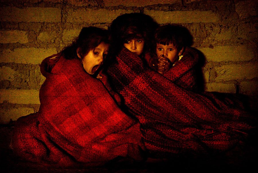 Terrified Iraqi children protect themselves from  the cold after they're taken outside their house during a pre-dawn raid  in a suburb of Baquba on November 16, 2003. Damir Sagolj / Reuters  .    #warphotography #historicphotography #photography