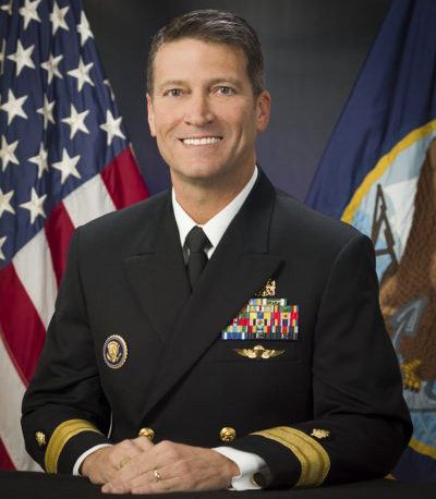 Rear Admiral Ronny Jackson in military attire posed in front of the U.S. flag
