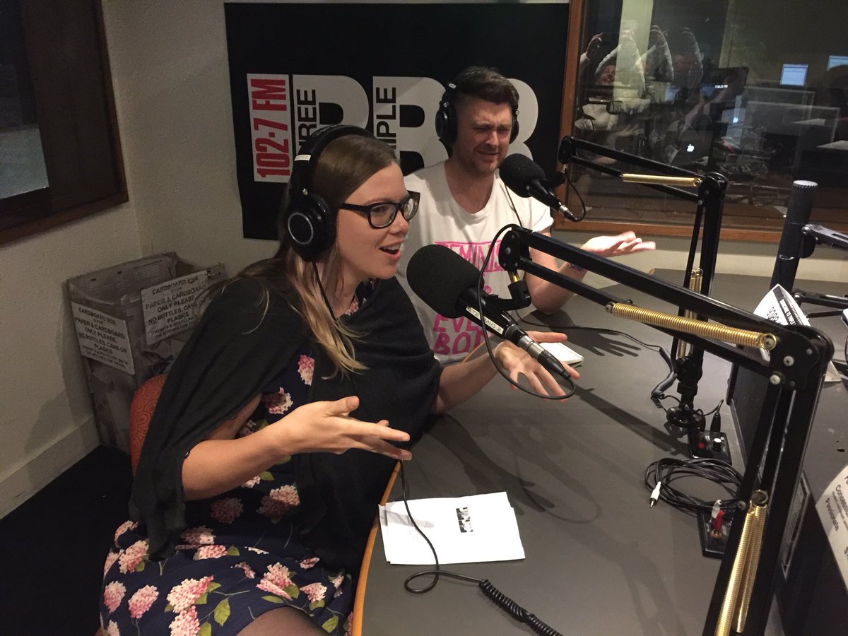 Woman and man on microphones in a radio station
