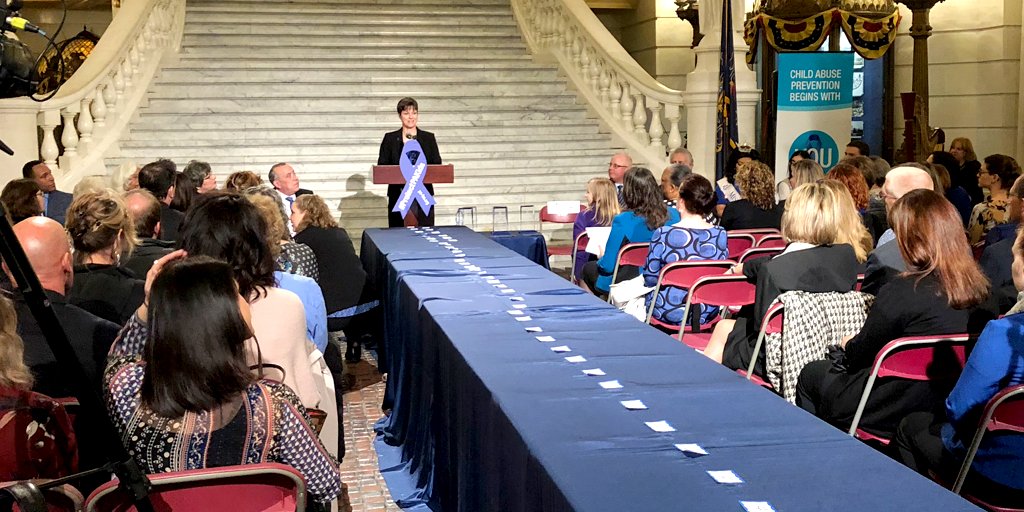 DHS Secretary Teresa Miller speaks to a crowd of people from a podium in front of the Capitol Rotunda stairs.