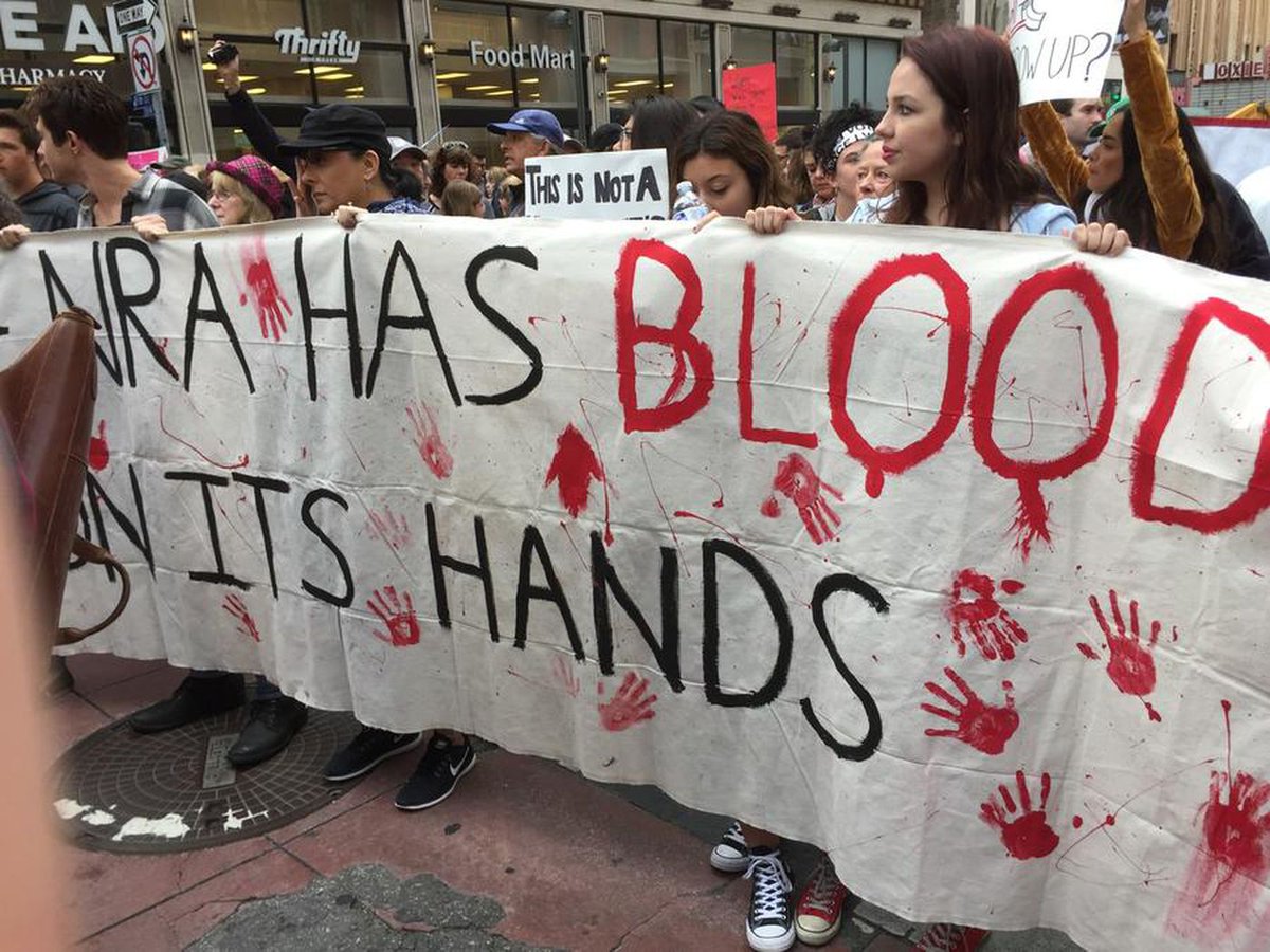 latimes's tweet photo. "The NRA has blood on its hands": Signs from March for Our Lives rally in Los Angeles https://t.co/00jQJxZTGC https://t.co/BHFAfYLFrh