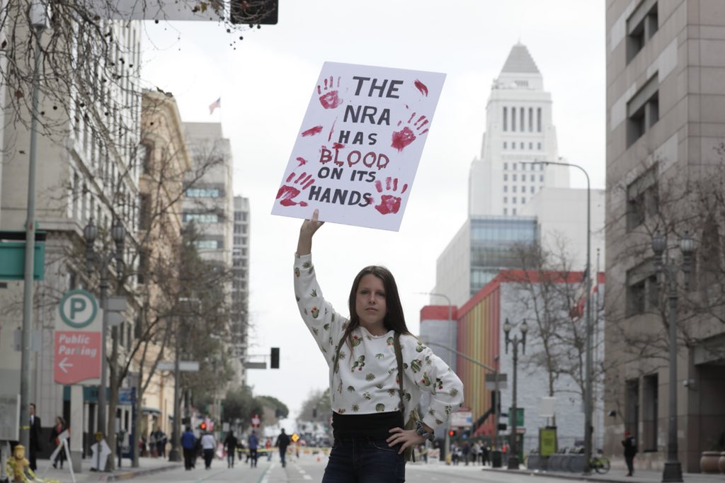 latimes's tweet photo. "The NRA has blood on its hands": Signs from March for Our Lives rally in Los Angeles https://t.co/00jQJxZTGC https://t.co/BHFAfYLFrh