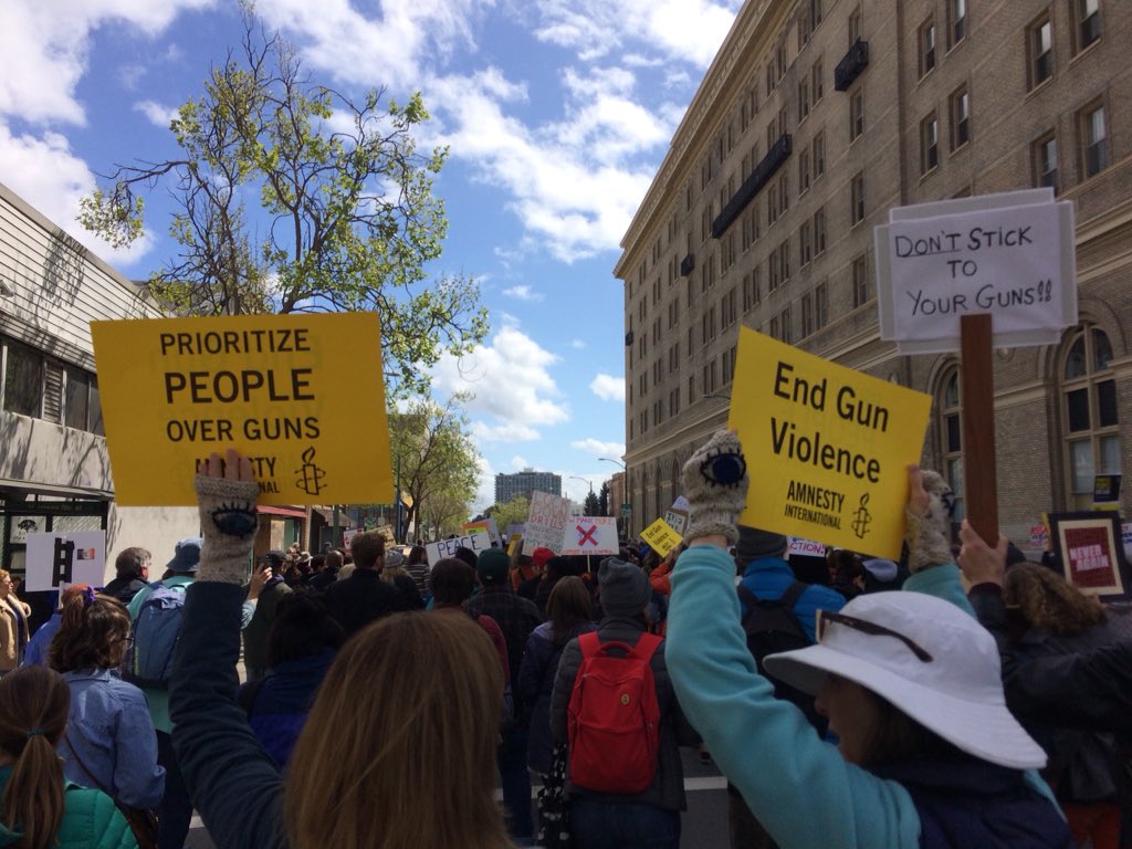 AmnestyWest's tweet photo. Amnesty International #EndGunViolence signs were so high in demand at the rally and march in Oakland I had to go back to the office three blocks away to print out more. 140 distributed in a few hot minutes. Let’s keep the momentum going! #MarchForOurLives #NeverAgain https://t.co/u3ewi9FCqq