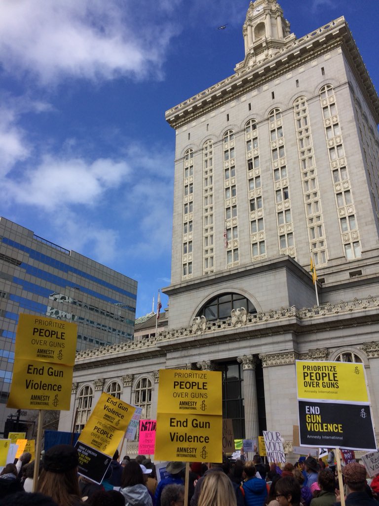 AmnestyWest's tweet photo. Amnesty International #EndGunViolence signs were so high in demand at the rally and march in Oakland I had to go back to the office three blocks away to print out more. 140 distributed in a few hot minutes. Let’s keep the momentum going! #MarchForOurLives #NeverAgain https://t.co/u3ewi9FCqq