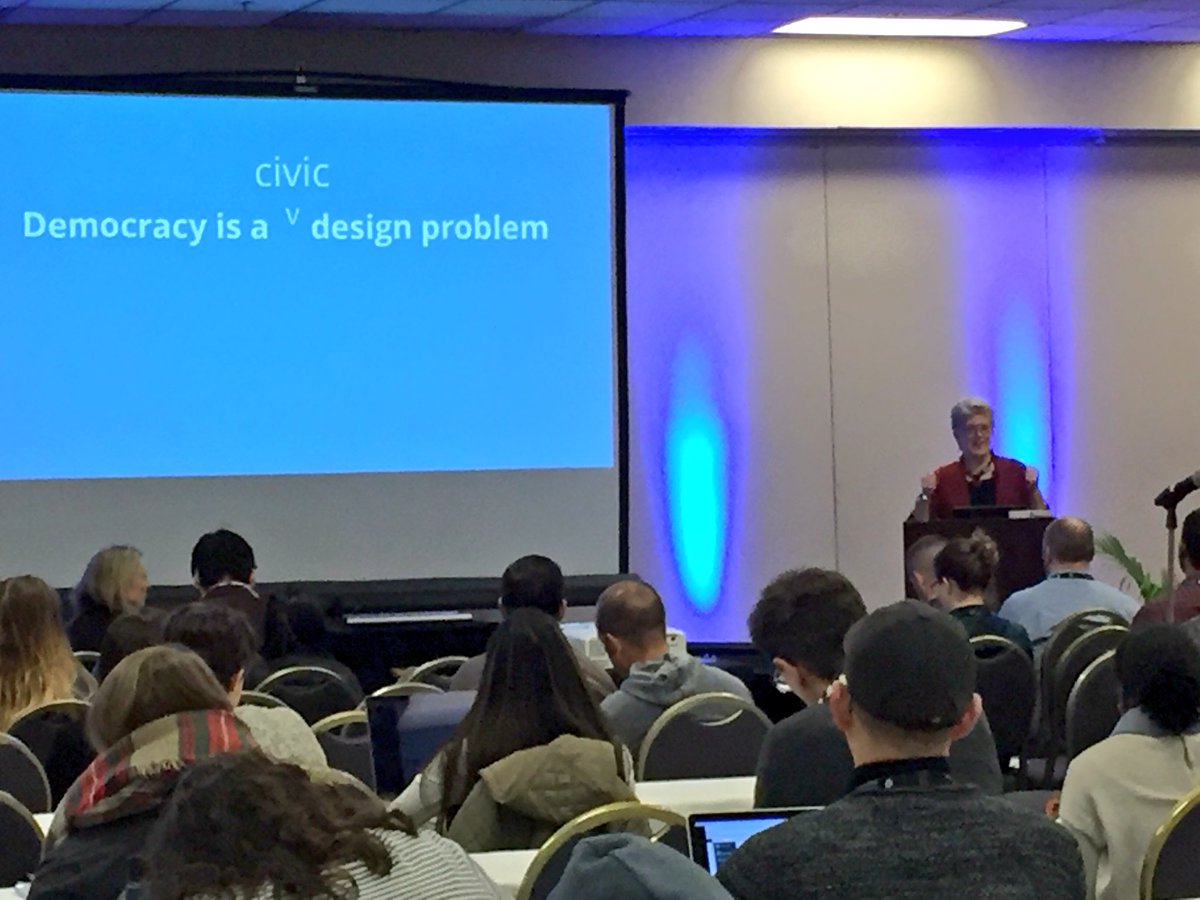 Presentation slide showing tag line with Whitney at the podium