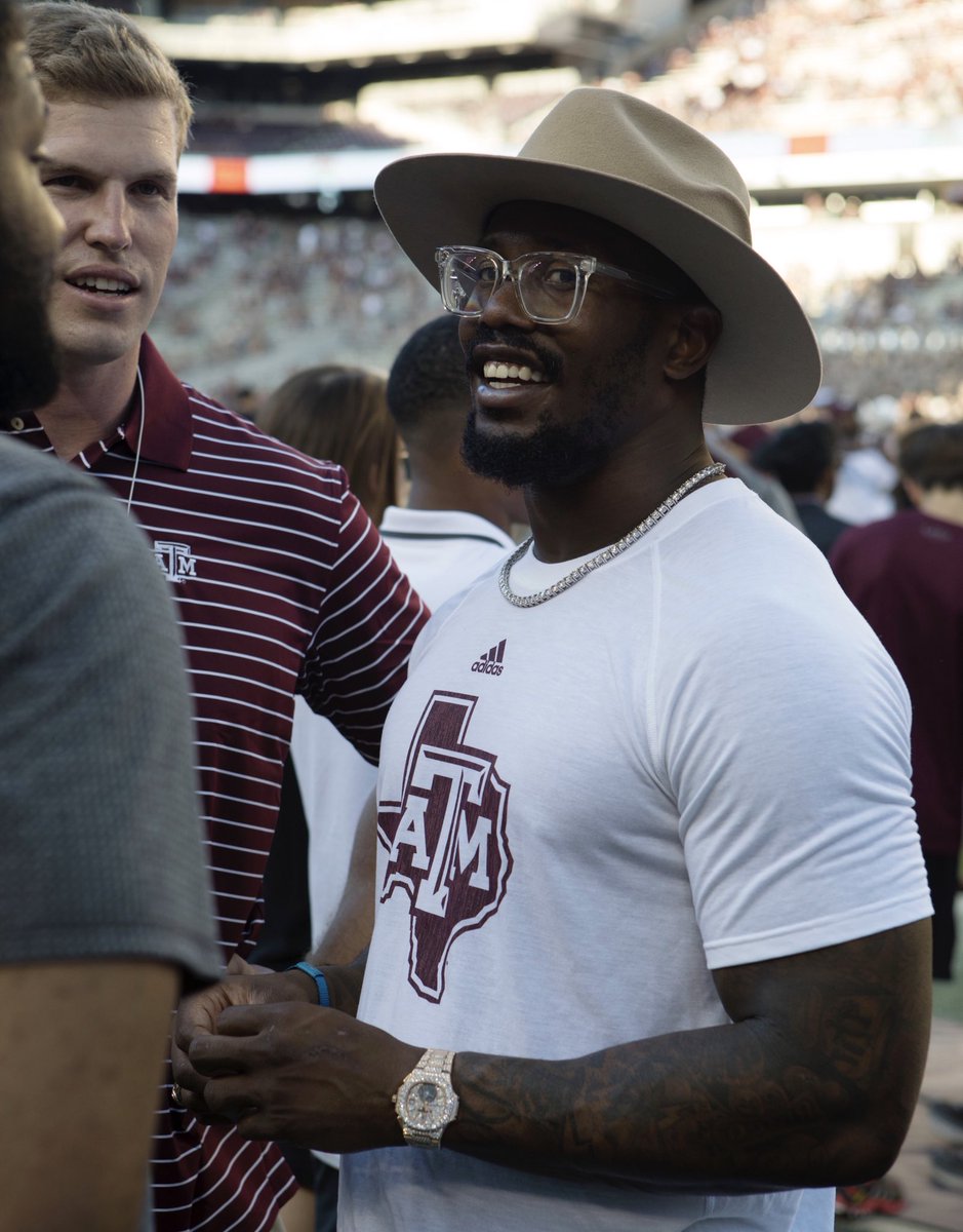 Von Miller wearing a Texas A&M shirt and smiling at a football game in Kyle Field