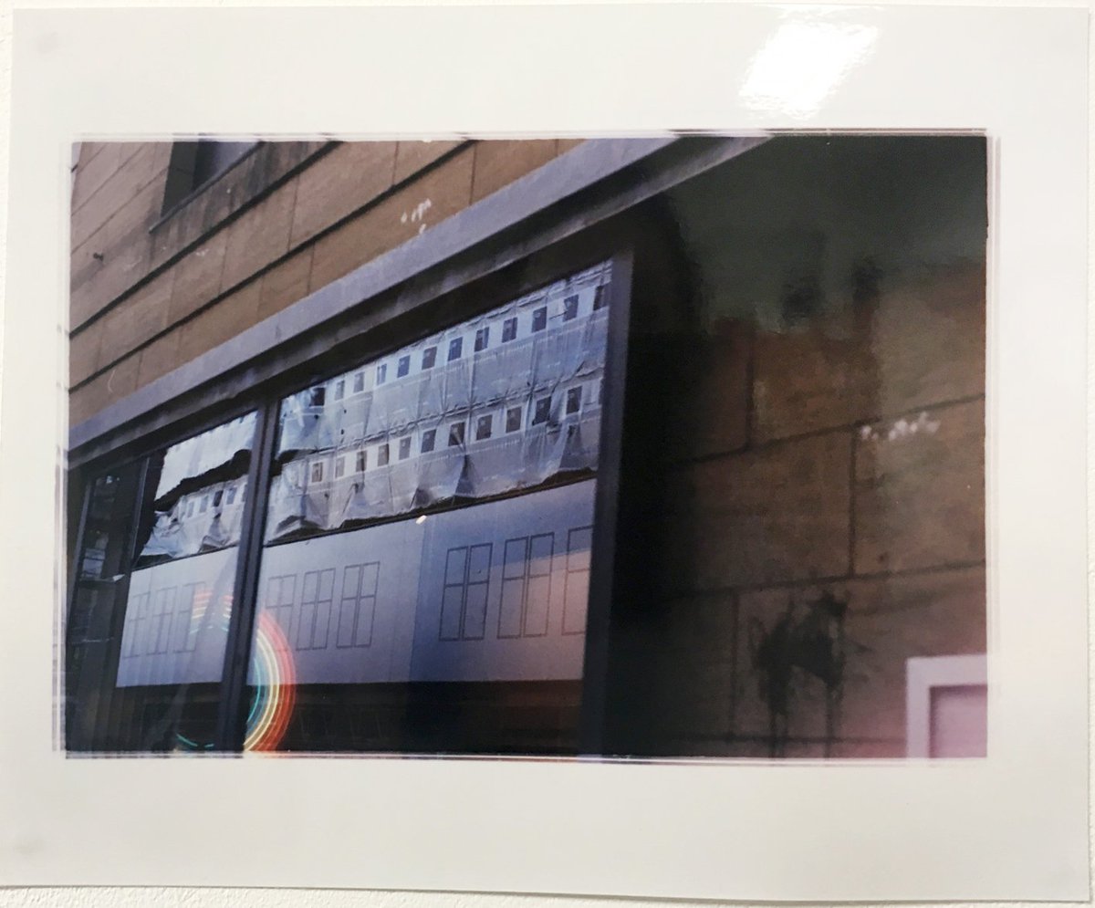 A photographic print of rainbow fluorescent lights captured in a window frame.