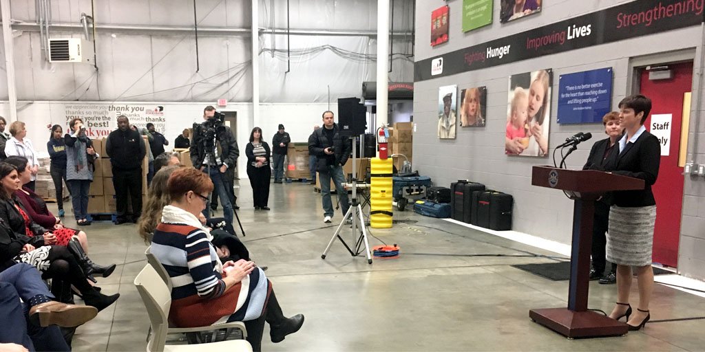 DHS Secretary Teresa Miller speaks in front of a crowd at the Central Pennsylvania Food Bank.