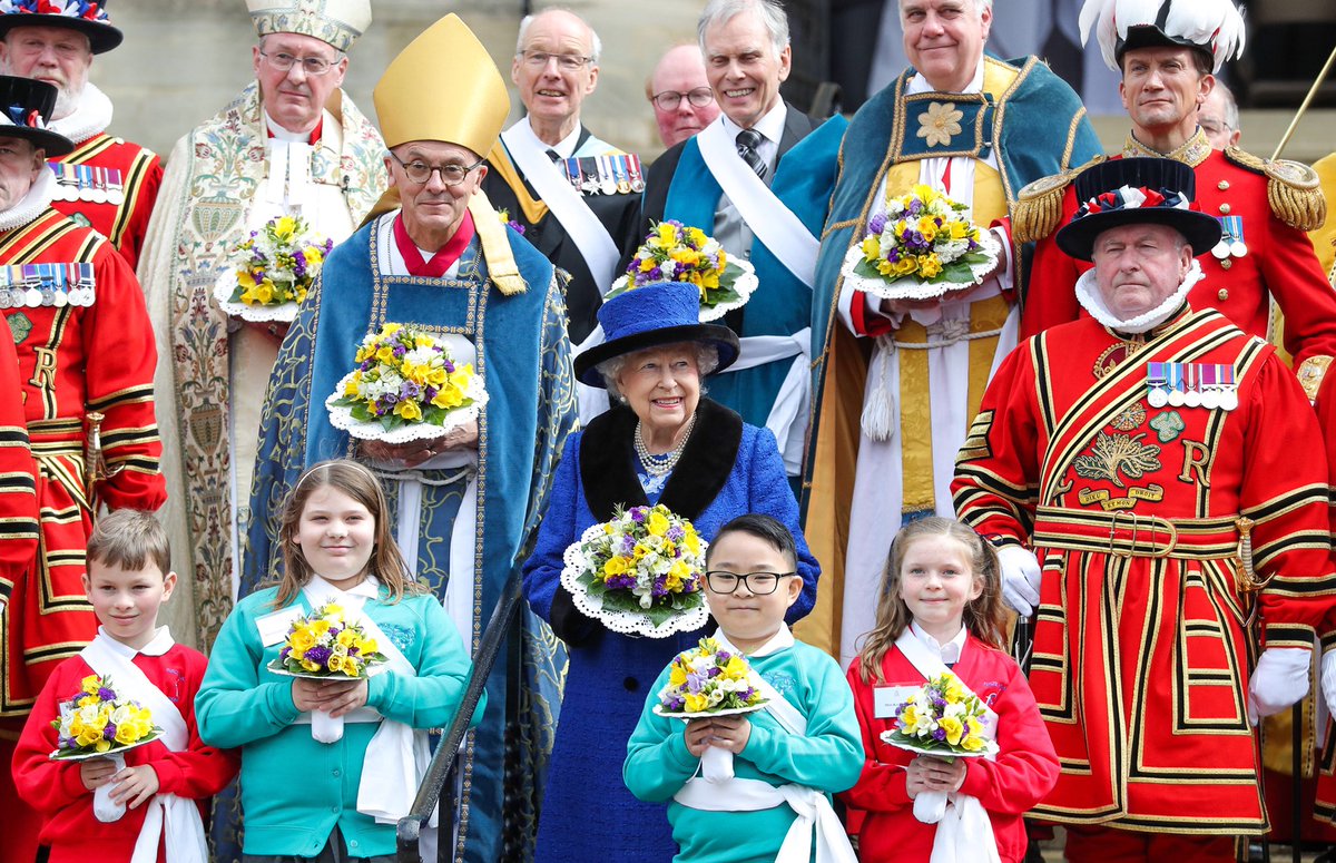 After the Maundy Service, The Queen stands on the steps of St. George’s Chapel alongside those who had taken part in the service, including children from schools in Slough and Maidenhead.