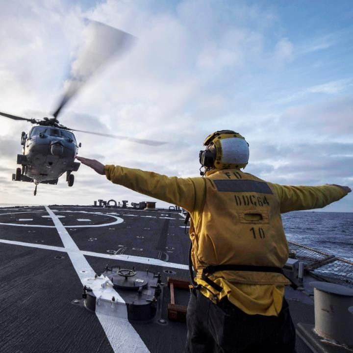 A #USNavy #Sailor signals to an #MH60S Sea Hawk #Helicopter, assigned to the #GhostRiders of Helicopter Sea Squadron #HSC28, during flight quarters aboard the Arleigh Burke-class guided-missile destroyer #USSCarney #DDG64 in the #MediterraneanSea. #Pilot