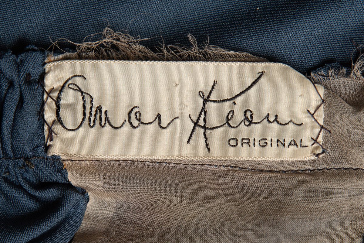 ChicagoMuseum's tweet photo. #OnThisDay in 1894, #OmarKiam was born in Monterrey, Mexico. He was a fashion designer before & after creating costumes for Broadway & Hollywood productions. This silk jersey dress (c. 1940) has an embroidered sash & tassel. See it in #SilverScreenChi. https://t.co/20XS63fX1v https://t.co/EzG8X5J3k9