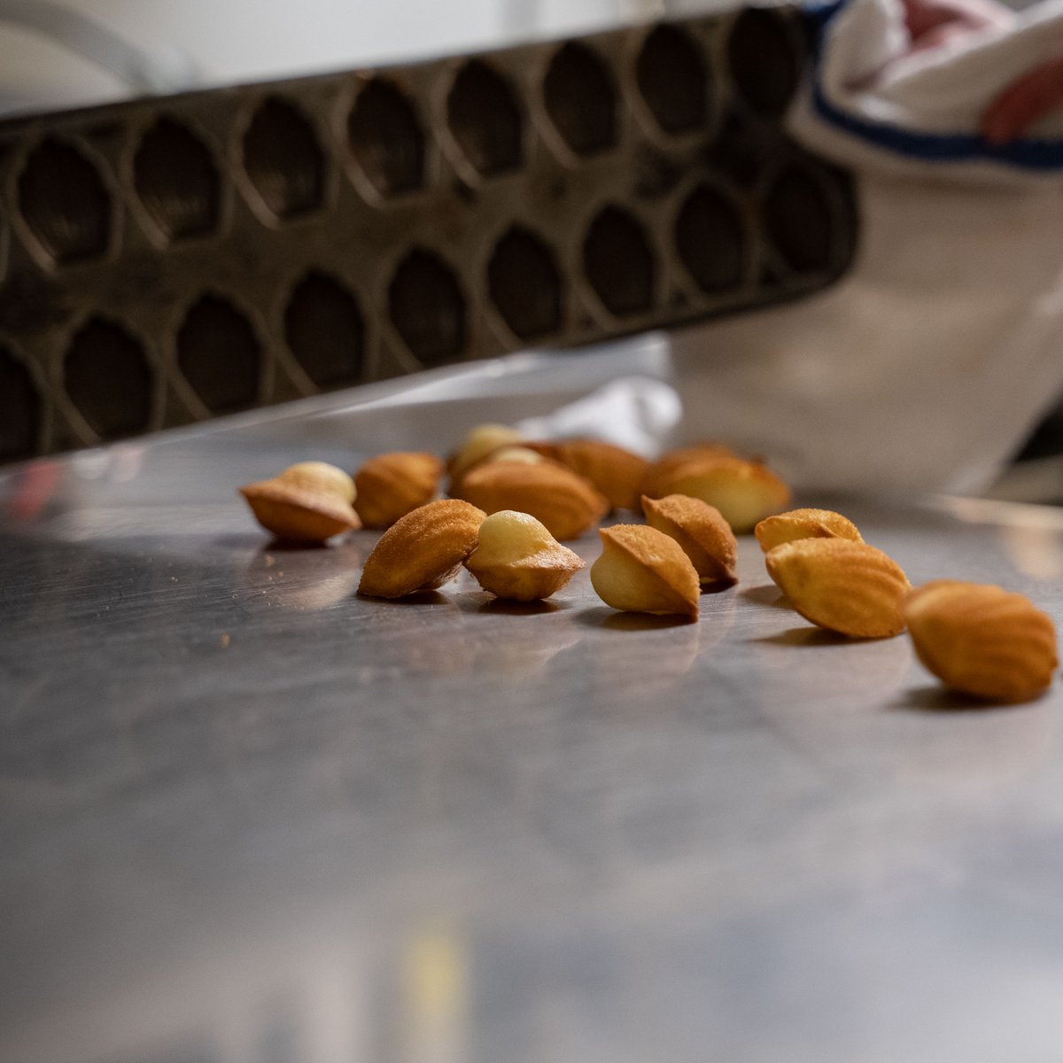 If you were to step into our kitchen for a little tour, you might hear a sharp *CLACK* of metal on metal every now and then. It’s a signature sound in Chef Daniel Boulud’s kitchens, indicating that another batch of our Madeleines is fresh out of the oven! #pastry #madeleines