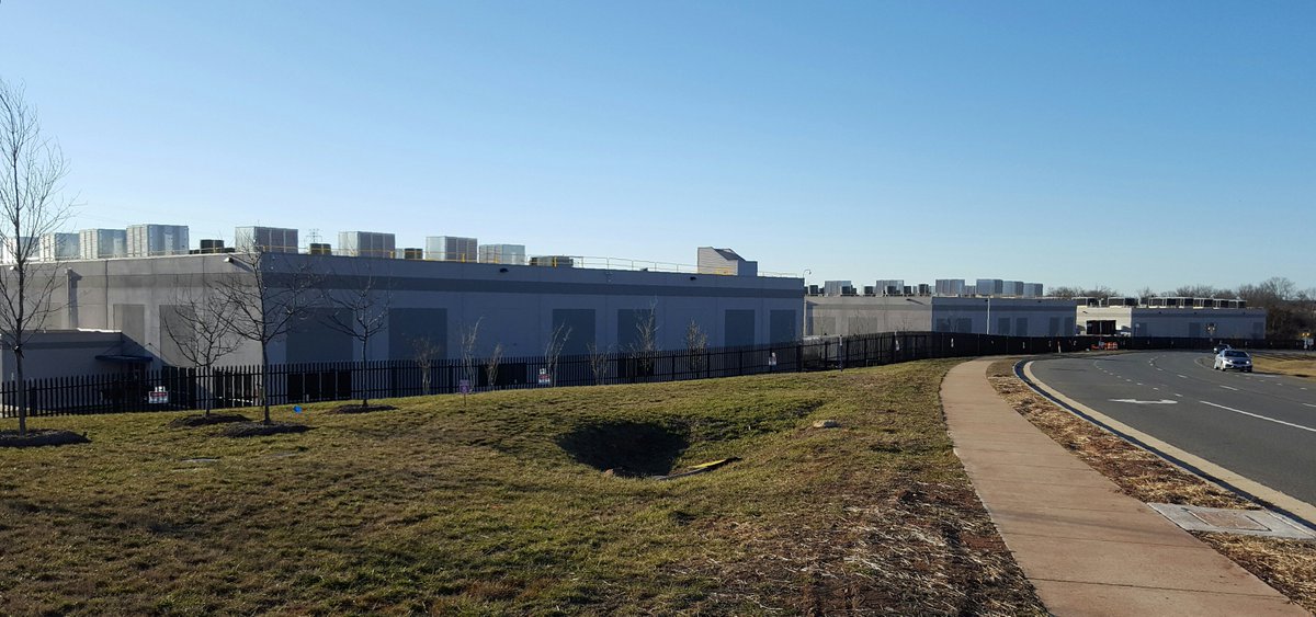 ForUsNotAmazon's tweet photo. A note on the Amazon cloud- "cloud" makes us think that data is in some otherworldly tech space. But actually the cloud looks like this- they're buildings where all our information is physically stored and kept running.

These AWS data centers in Ashburn, Va #AmazonvsImmigrants https://t.co/Ab7rGQiB2Q