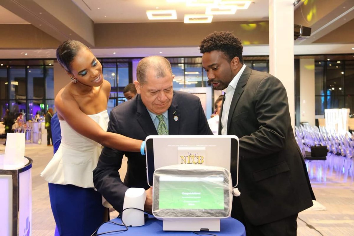 AudleyShaw's tweet photo. CEO of the WiPay software development company, Aldwyn Wayne (right), demonstrates the use of the Wipay e-commerce platform to Hon. Audley Shaw (centre), at the launch, at the AC Marriott hotel . At (right) is compère, Terri-Karelle Reid. https://t.co/IqlLVW7AyK