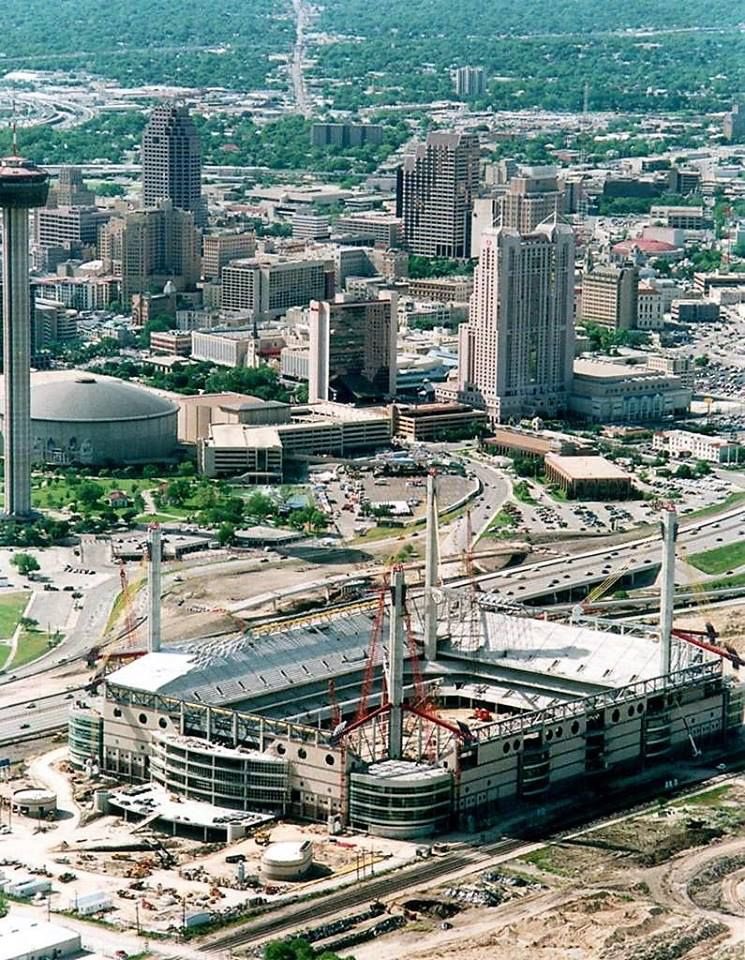 ArenasStadiums's tweet photo. A very cool photo showing the @Alamodome dome under construction in 1992. The facility opened in 1993. On the far left, the #HemisFairArena, which closed in 1995, can be seen. Both buildings have been previous homes to the San Antonio @spurs. #TexasArenas #TexasStadiums #Spurs https://t.co/MyXtPsuzd0