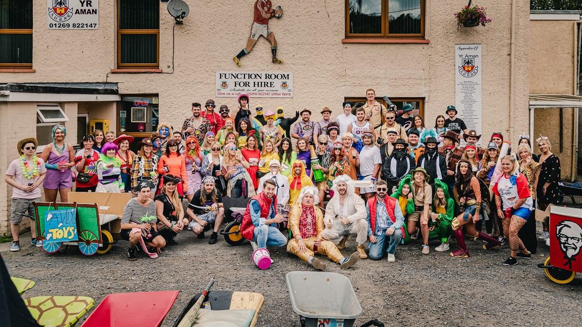 LATCHWales's tweet photo. 80 people took on Ammanford’s @BarrowRacers Challenge on 6th July. The annual wheelbarrow race is a six-mile real life wacky racers bar crawl event where teams dress up in costumes, with £750 raised for LATCH. Huge thanks to Nick Francis and everyone who took part on the day! 💜 https://t.co/xFT9qYqnwK