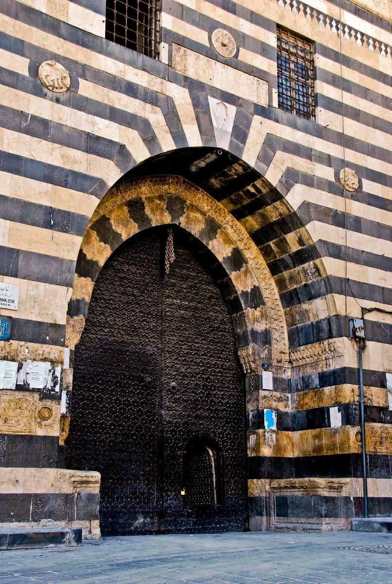 I found this picture online tonight. It is the "[e]xterior of entrance portal" to Khan al-Wazir in Aleppo, Syria. Looks familiar, right?  https://archnet.org/sites/2865/media_contents/75544