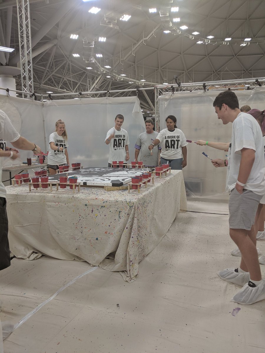 CUNE's tweet photo. After two days of hard work, the @jeffvzquest artwork is complete! First, students splattered paint to represent the sin that is messy (no matter how careful we are!). Then they painted over the lines to show how Jesus takes away our sin and makes us whole. ❤️ #CUNE #NYG2019 https://t.co/vJvYv0RN7T