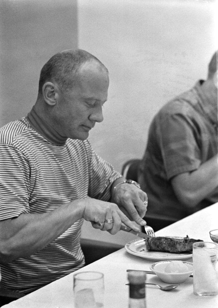 Buzz Aldrin eating a steak. 