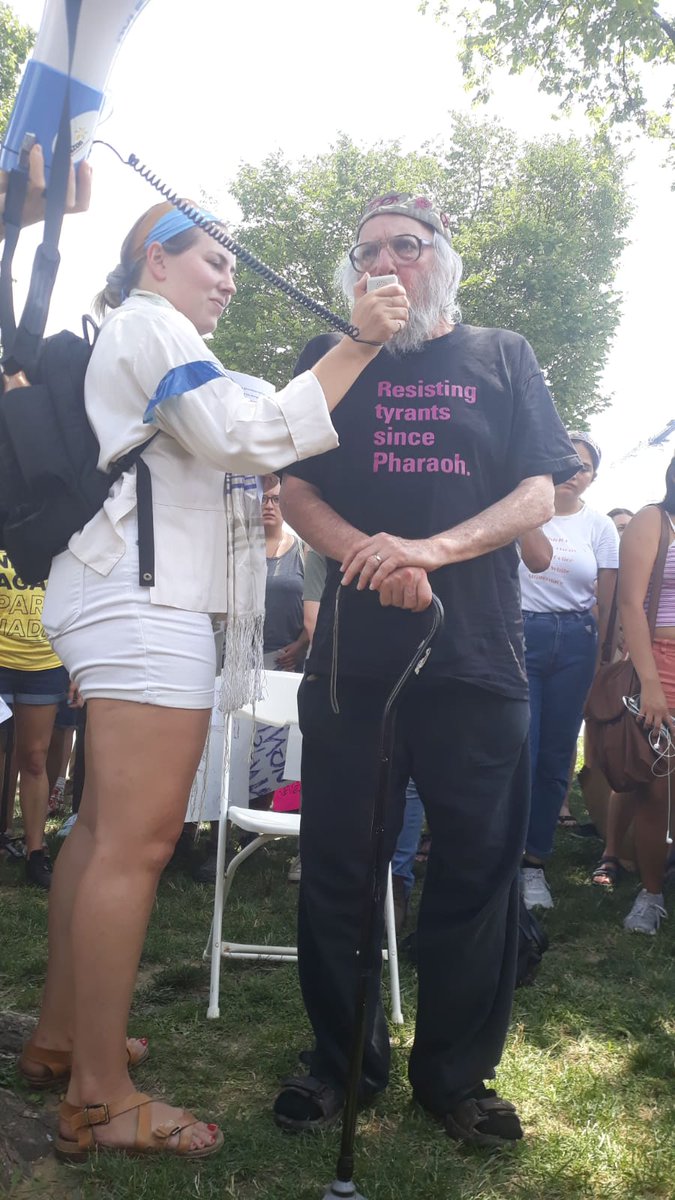 Rabbi Arthur speaks into the megaphone to the crowd.