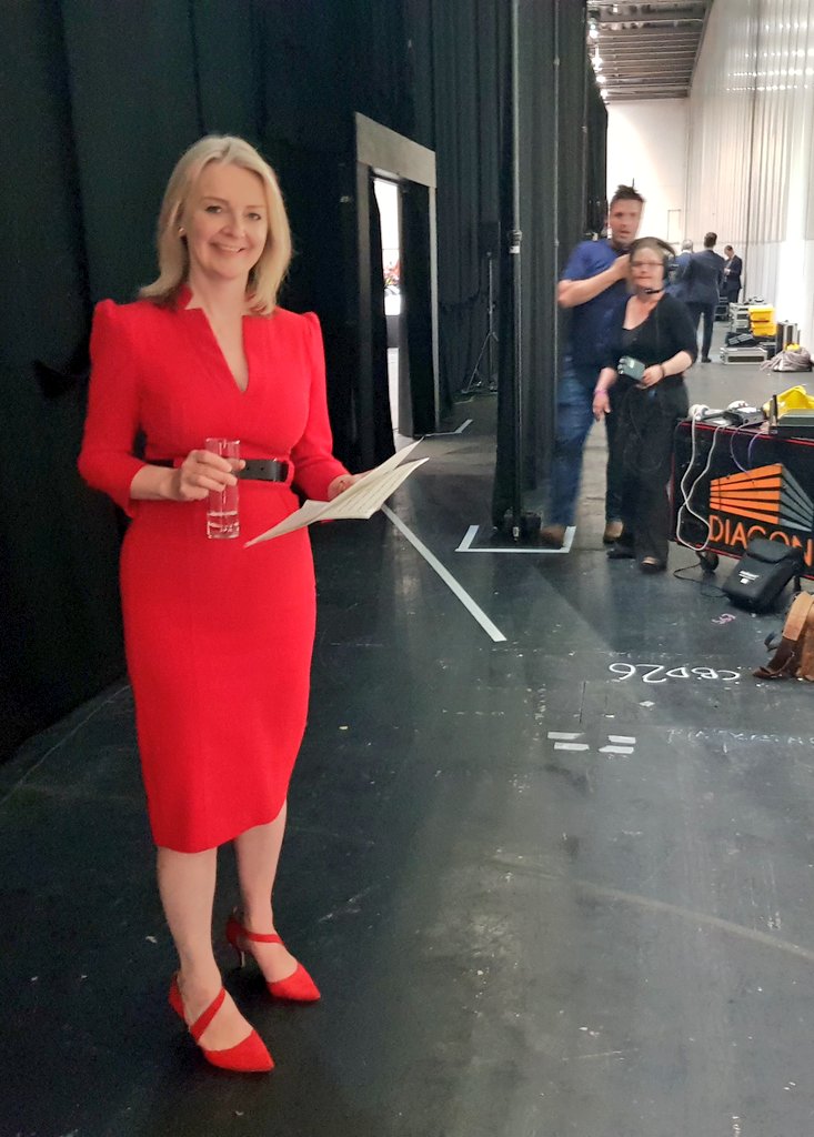 liz truss red dress Liz Truss, then Chief Secretary to the Treasury, walks unrecognised in Westminster in red dress and shoes with matching red-rimmed sunglasses Stock Photo