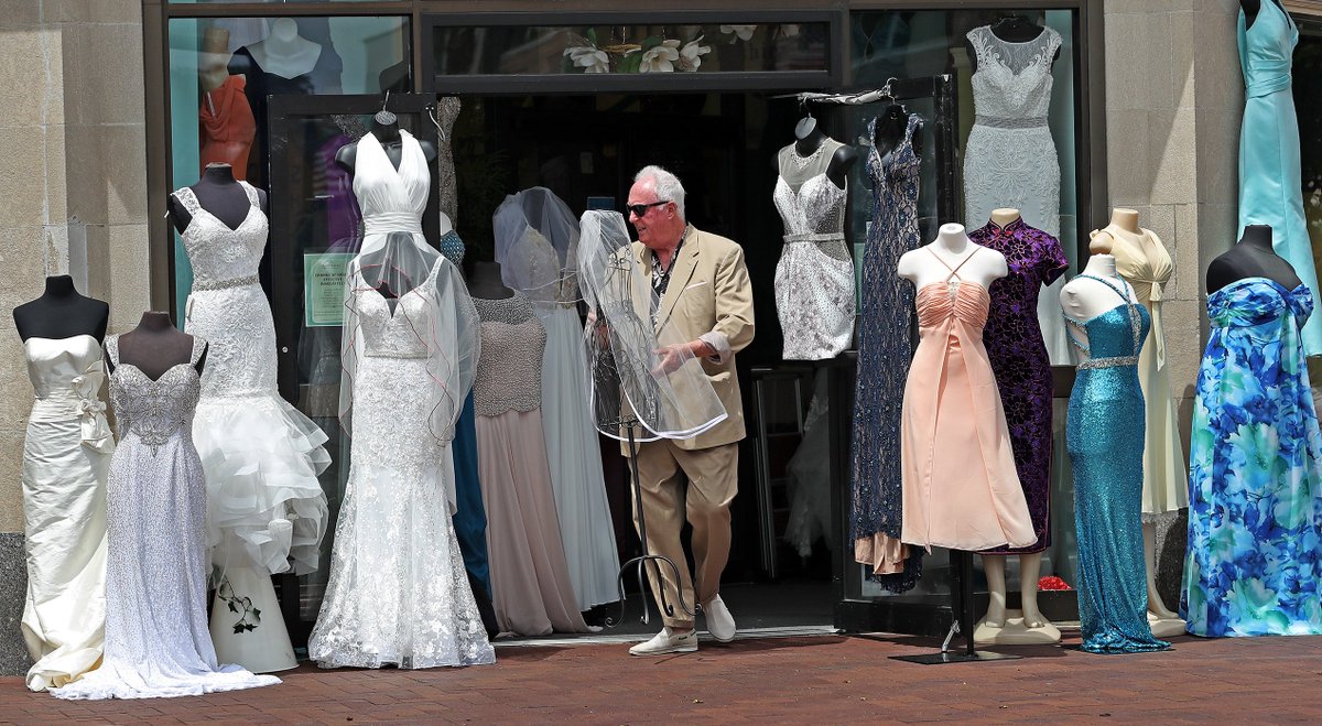 OUTDOOR BOUTIQUE.......deisigner Jaydee Donahue brings out a fashon item to be displayed at GRANDASIA a bridal prom and fashon shop in Quincy center displayed outside some of it's stock on a warm summer day