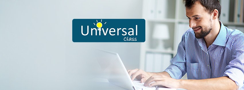 a man smiling as he looks down at his laptop. He's sitting at a desk.