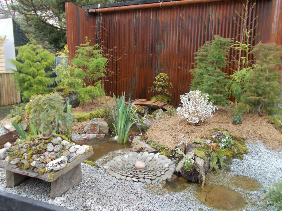 GreenFingerBlog's tweet photo. Strangely beautiful combination of rural and industrial Japanese landscapes in the Disequilibrium Garden by @mikefurse at #RHSCardiff Thos trees are awesome! Plenty of #upcycling in here from rusty barrel to a re-bar bridge. And I love the pebble rosette - nice touch. https://t.co/eKoUmn0jsq