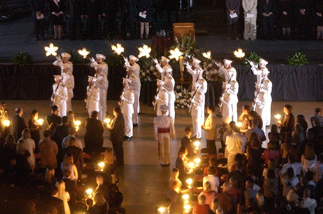 A 21 gun salute being performed in front of a crowd at a Muster Ceremony on campus