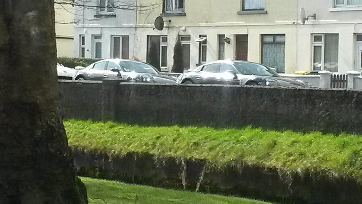 A couple of 4 door Porsche's with camouflage tape.