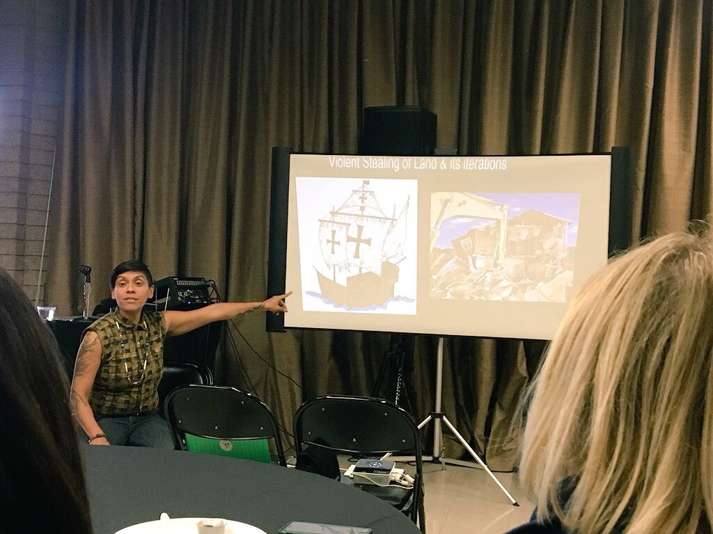 USC_SCAPF's tweet photo. “Queer Places and Urban Spaces” facilitator Rio Oxas guides us through past gentrification: “Calling it colonization is a problem because it uses the colonizers’ language—viewed as a positive thing. We say ‘violent stealing of land!’” #SCAPF2018 https://t.co/xifVv5qvU3