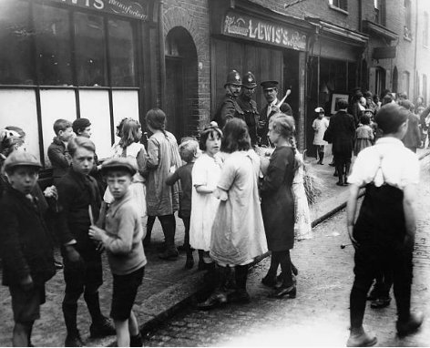 walk_ing_London's tweet photo. A group of children and police outside a shop where a murder took place - Hare Street (now Cheshire Street), #BethnalGreen, #London, July 1922. https://t.co/VOdQNUuFSw