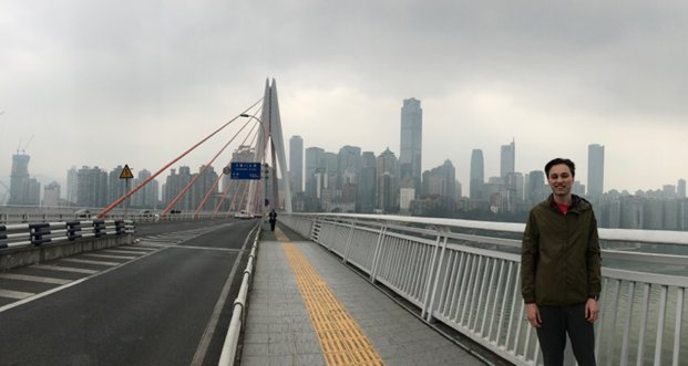 ucdiplomats's tweet photo. Photo of our Diplomat, Taylor, with Chongqing skyline in the background. The bridge is a famous bridge in Chongqing called Twin River Bridges.  #china #ucengineeringdiplomats #jci @UC_Global @UC_CEAS @ucunivhonors https://t.co/0uRLLSG02m