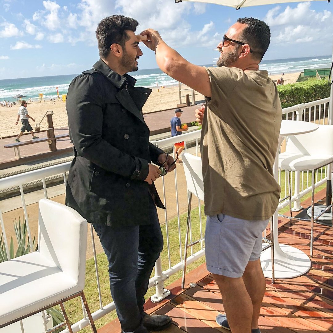 ArjunKapoorCafe's tweet photo. [NEW PICS] Soaking in the sun☀ getting ready for the show!!!😍💖
Our Main Man @arjunk26 with Hair-MakeUp Artist SteveMena in GoldCoast!😊👌👌 #BTS 
Styled by @vainglorious_in 😀
@Longines #LonginesMomentKeeper 
#CommonwealthGames2018 
#ArjunInAustralia 😁✌😇 https://t.co/0NqjjfBkLg