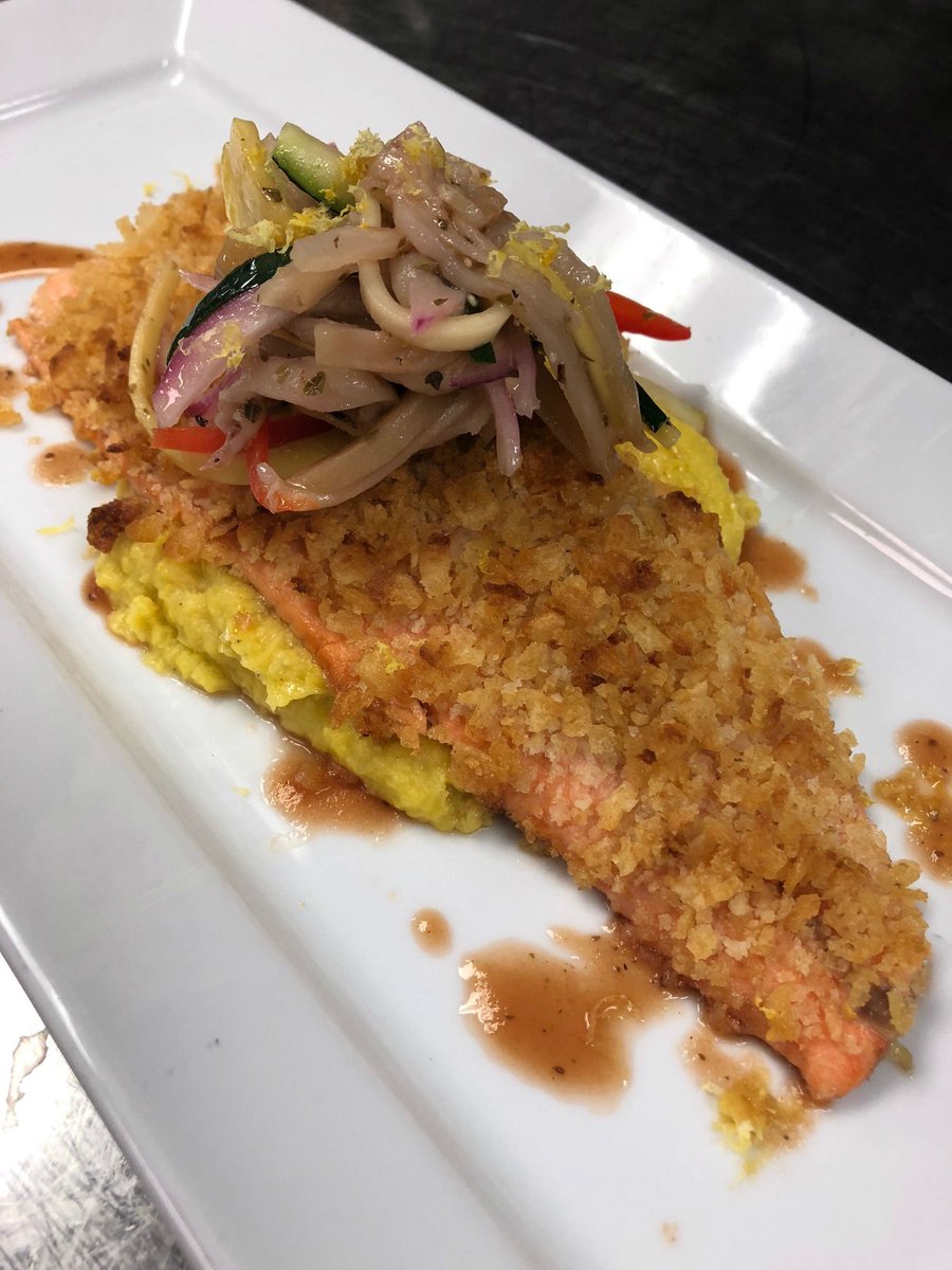 Our Chef's take on "Fish &amp; Chips", potato chip crusted ruby red trout served over corn puree, drizzled with Bloody Mary sauce, and topped with pickled vegetables. Stop by Share Bistro today.