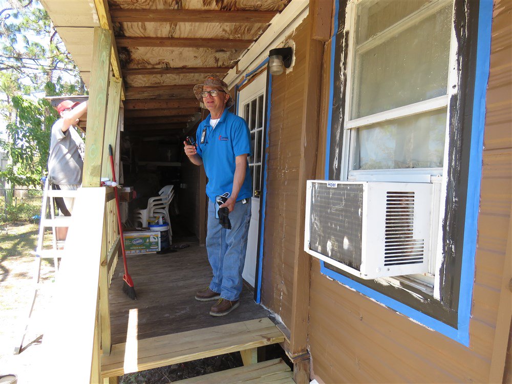 FLUMC's tweet photo. FLUMC construction coordinator Paul Crotty stands on the porch, near the new steps, while Evan Brinnon paints trim. Click this link https://t.co/1HlHkg4nCO to join the journey to restore hope to the 2.6 million persons affected by Hurricane Irma. #flumcWeAreBigger https://t.co/UFfyNe1bTF