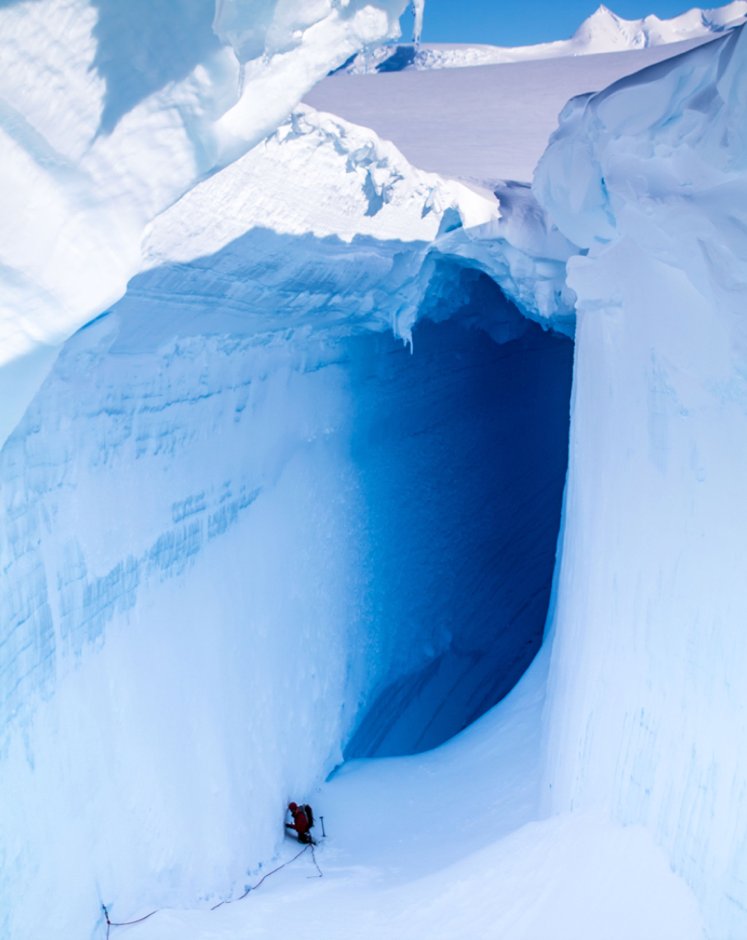 AntarcticReport's tweet photo. McCallum’s Pass, the access route to the far side of Adelaide Island, is littered with crevasses, concealing huge tunnels, caves and archways – many dwarfing the field personnel #Antarctica, pic Kate Dillon @BAS_News @NERCscience https://t.co/MMjzdpz2zI