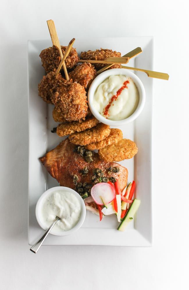 A fun twist on a traditional seafood platter! An appetizer platter for the hungry. Crispy pretzel rolled haddock lollipops with tartar sauce,  hot smoked salmon, quick pickled vegetables, lemon tarragon cream. #syscomaritimes