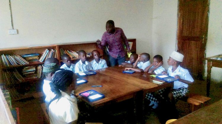 worldreaders's tweet photo. "Today, I walked into Nakaseke Library 80kms north of Uganda. I found librarian Peter conducting a library lesson. They were reading a story, learning new words, noting them down and looking them up in the dictionary." - Joan Mwachi-Amolo, Worldreader's Director of East Africa. https://t.co/PE2tI4i6FR